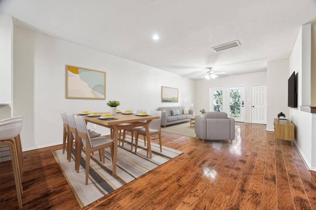 Dining and living room with hardwood floors, fresh paint touch ups, and a covered balcony! *virtually staged*