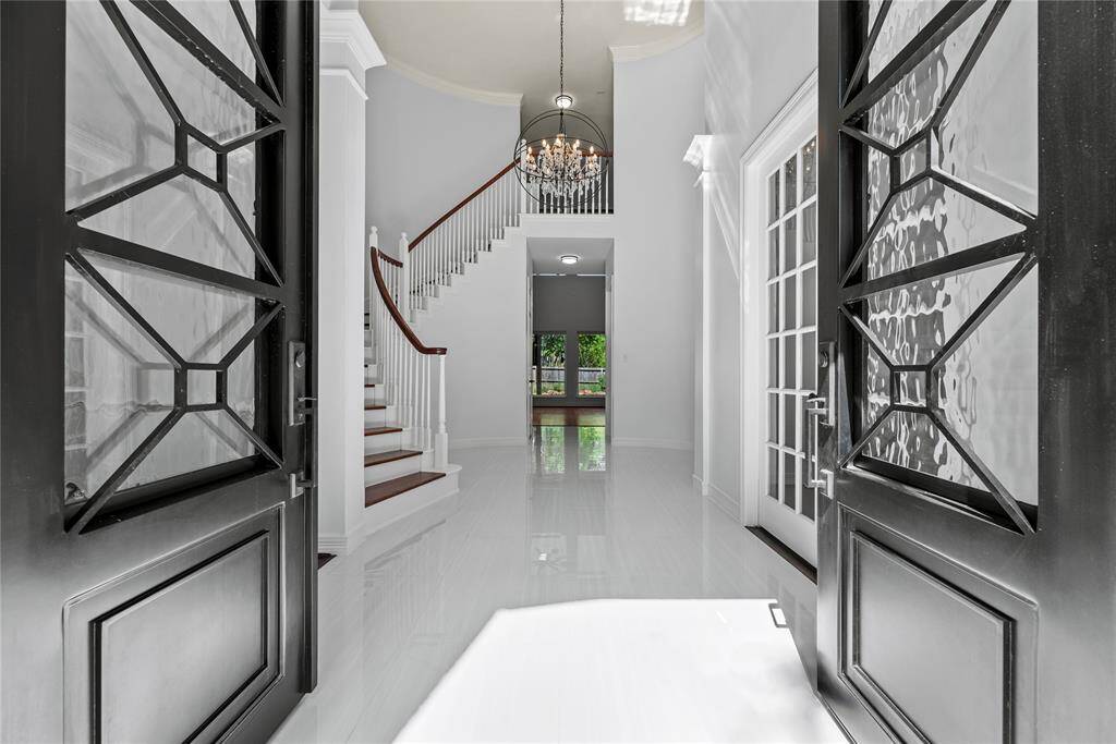 Beautifully presented porcelain flooring as you step through the custom iron double doors at 3415 Stepping Stone!