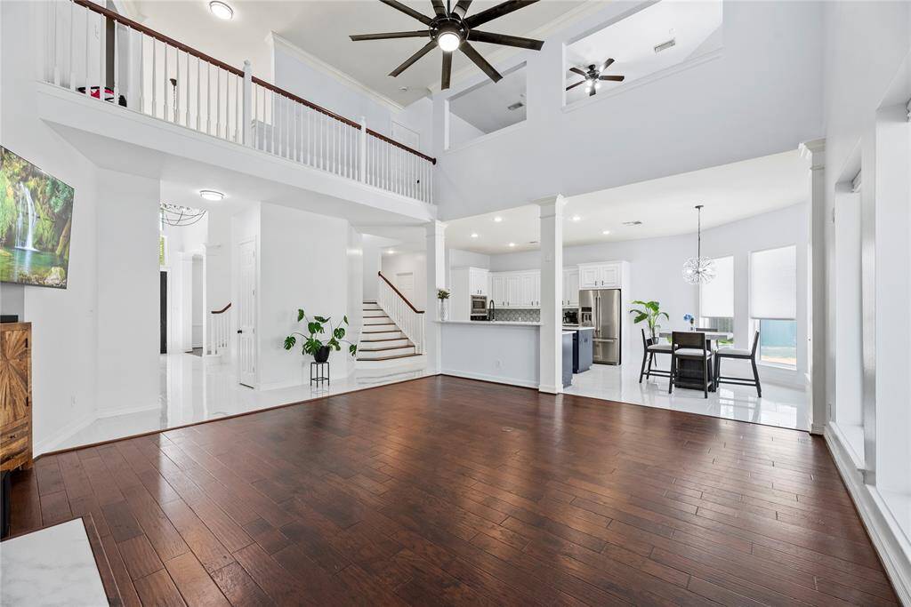 Open-concept living space with 19' ceilings, seamlessly flowing into the bright kitchen and breakfast area.