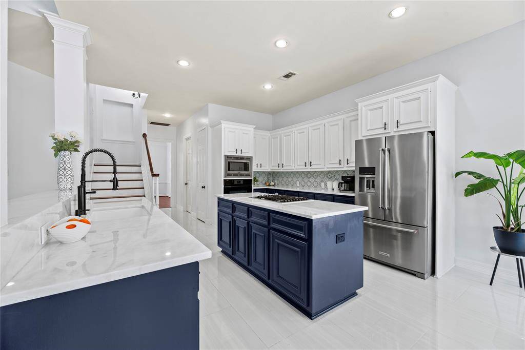 This updated kitchen features white quartz countertops and stainless steel appliances.