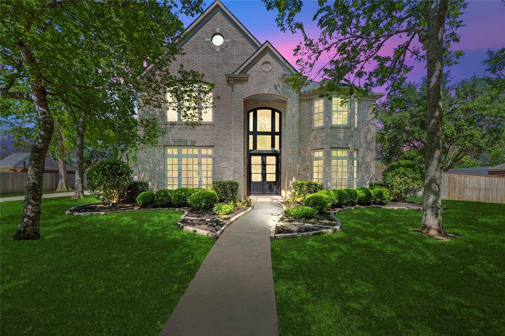 Breathtaking twilight view of the home, highlighting warm interior lighting and a stunning sunset backdrop, creating an inviting atmosphere.