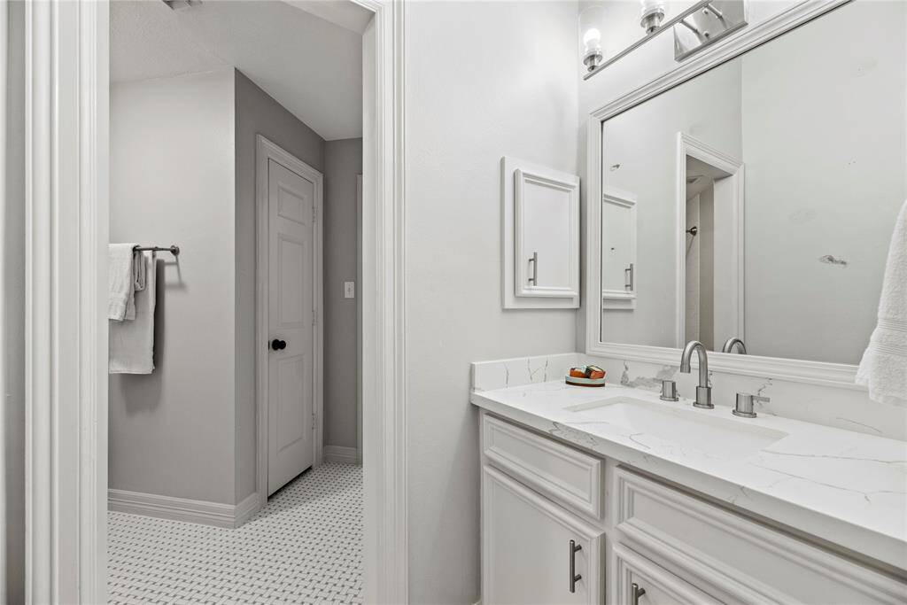 The Hollywood bath is adorned with charming basketweave tile and continues and supports another secondary bedroom