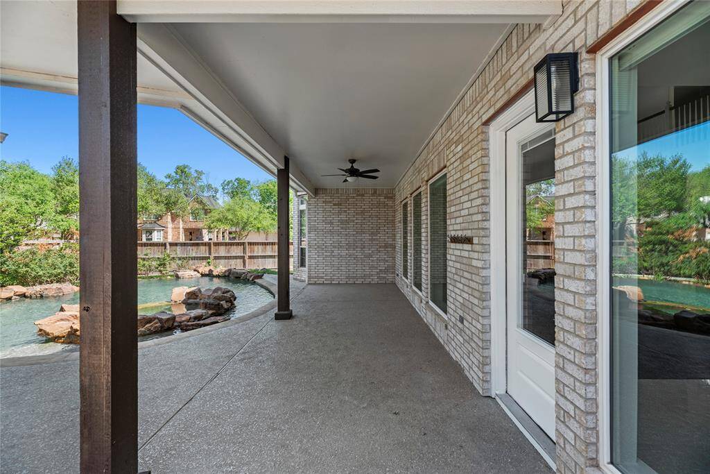Extended covered patio along the back of the home with ceiling fans – the perfect space for relaxing in the shade while enjoying poolside views.