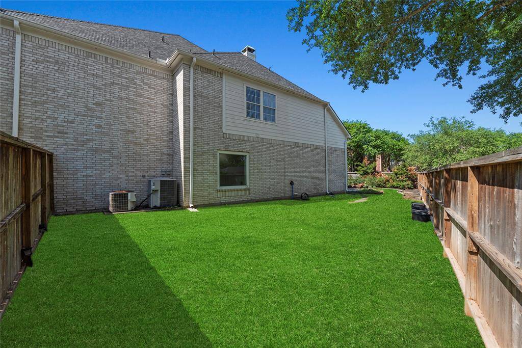 Large fenced side yard with well-maintained grass, perfect for pets, play, or additional entertaining space.