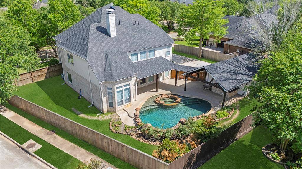 Beautiful backyard retreat with heated pool, hot tub, tanning ledge, covered pavillion with summer kitchen and lots of side yard!