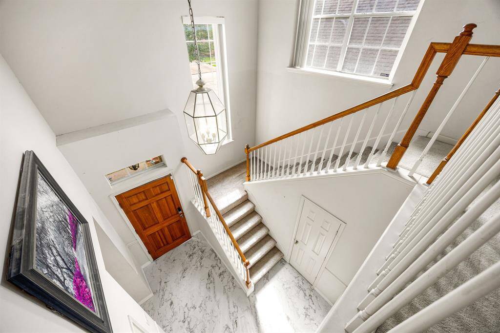 Inviting entry has a half bath tucked away under the stairs. Notice the natural light from the two stairway windows.