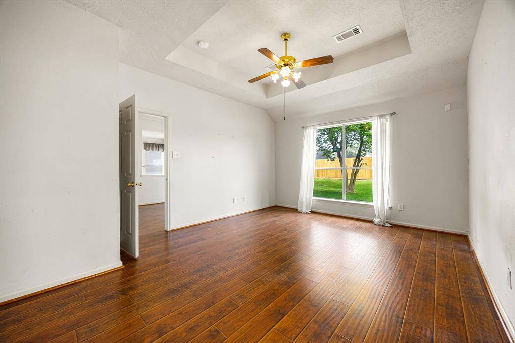 Primary bedroom has views of the large backyard and ensuite access to the primary bathroom.