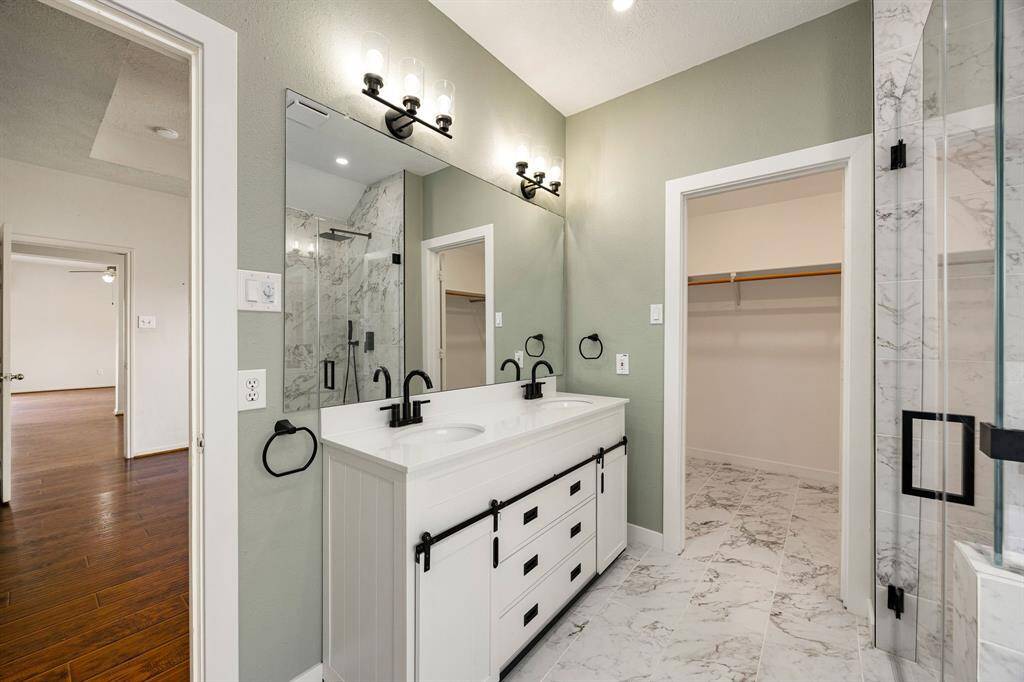 Primary bathroom has renovated double sinks, flooring to include the large walk-in closet, renovated shower, new soaker tub and more!