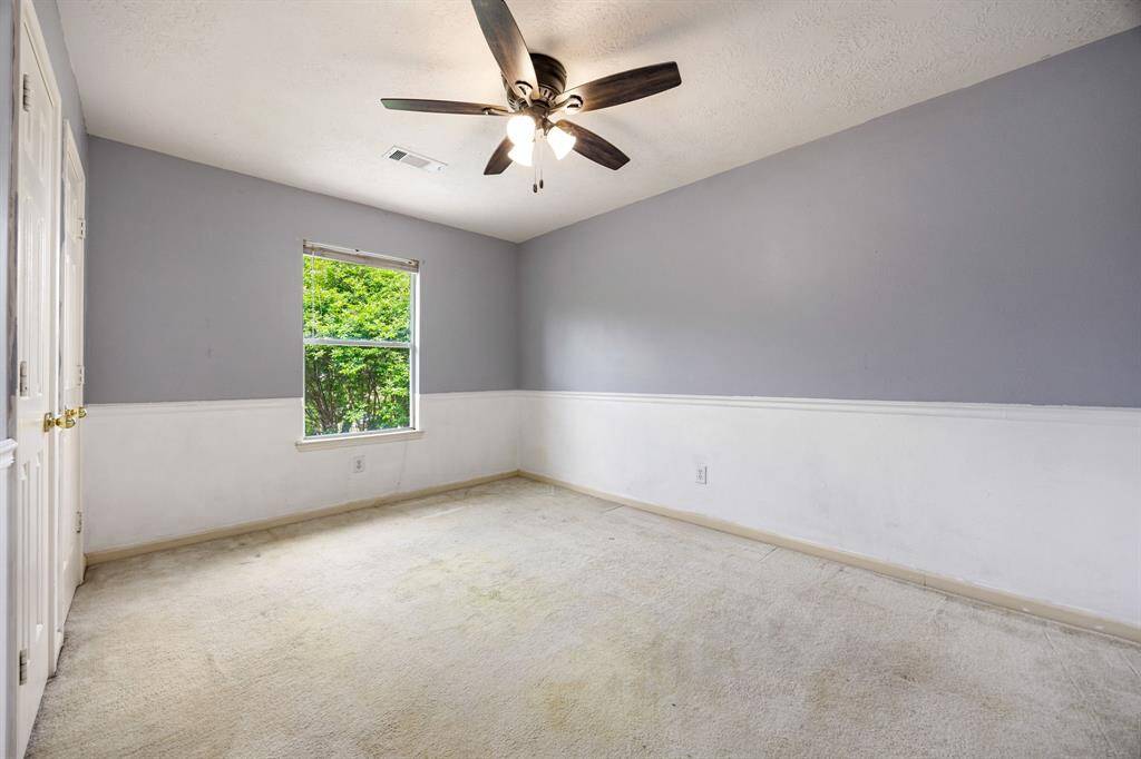 Secondary bedroom upstairs with neutral paint and decorative chair railing.