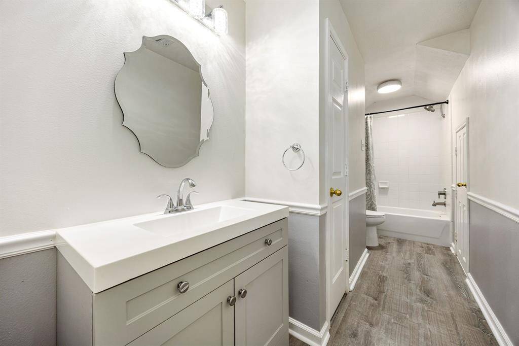 Shared bathroom upstairs has updated counter and sink along with wood-look vinyl plank flooring.