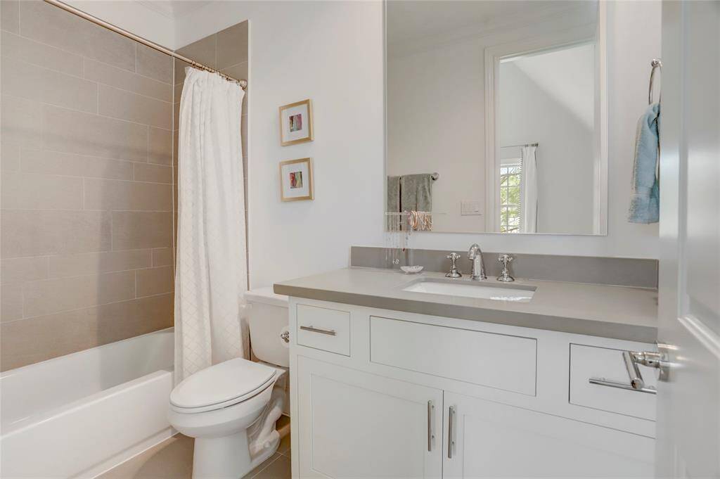 1 of 3 Secondary Bathrooms featuring Quartz countertops, large mirror, custom cabinetry, tub/showers & LED lights.