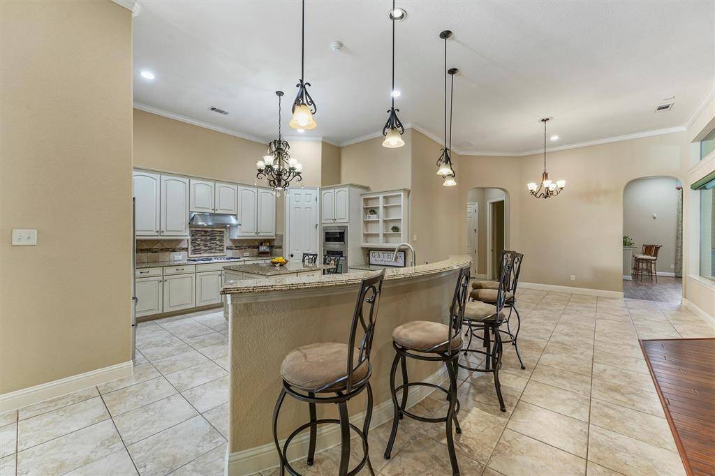 This spacious kitchen features elegant upgraded cabinetry, double islands with seating, stainless steel appliances, modern pendant lighting, 2 pantrys and a desk nook! Refrigerator and bar stools offered to convey with home.