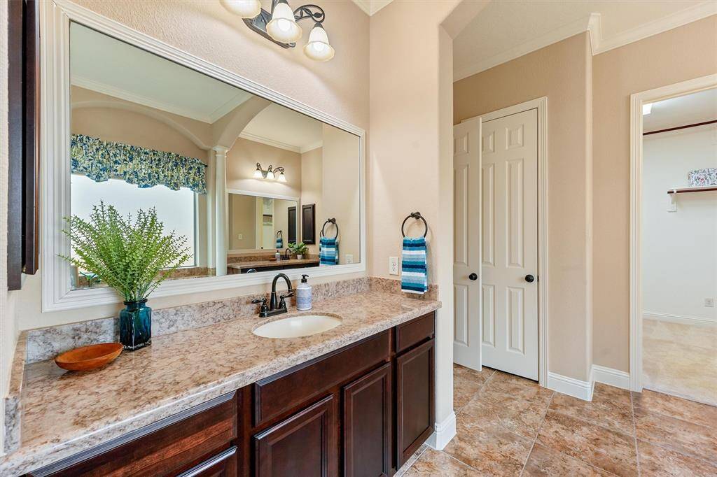 2nd vanity with large mirror, granite countertop and dark wood cabinetry.