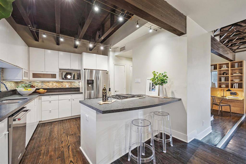 Kitchen outfitted with sleek cabinetry, honed granite countertops, and breakfast bar seating—perfect for casual meals and conversation.