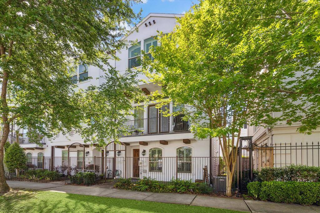 The front of 4237 Feagan Street is a beautifully maintained end-unit townhome in the gated Catalonia Court community. The exterior features a charming, fully fenced yard with lush K-9 grass turf and a soothing fountain, creating a serene and inviting atmosphere. The home boasts plantation shutters on all windows, adding a touch of elegance and privacy.