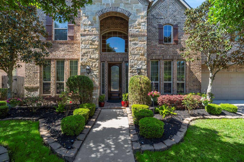 Immaculate 2-story custom brick and stone home offers luxury living with breathtaking water views in the distinguished Senova at Riverstone neighborhood.