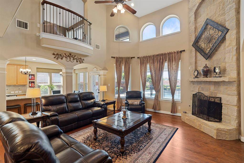The open-concept family room boasts an elegant coffered 2-story ceiling, creating a dramatic space for both relaxation and gatherings.