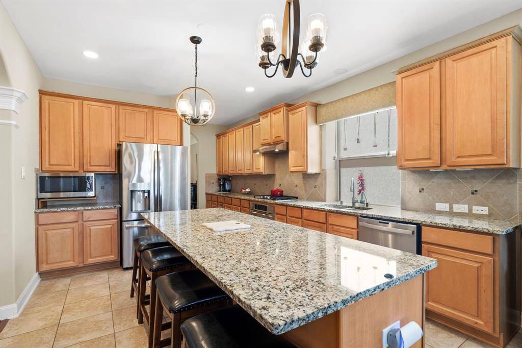This kitchen has it all—GE Profile stainless steel appliances installed June 2023, an expansive center island with breakfast bar, granite countertops, a walk-in pantry, and so much more!