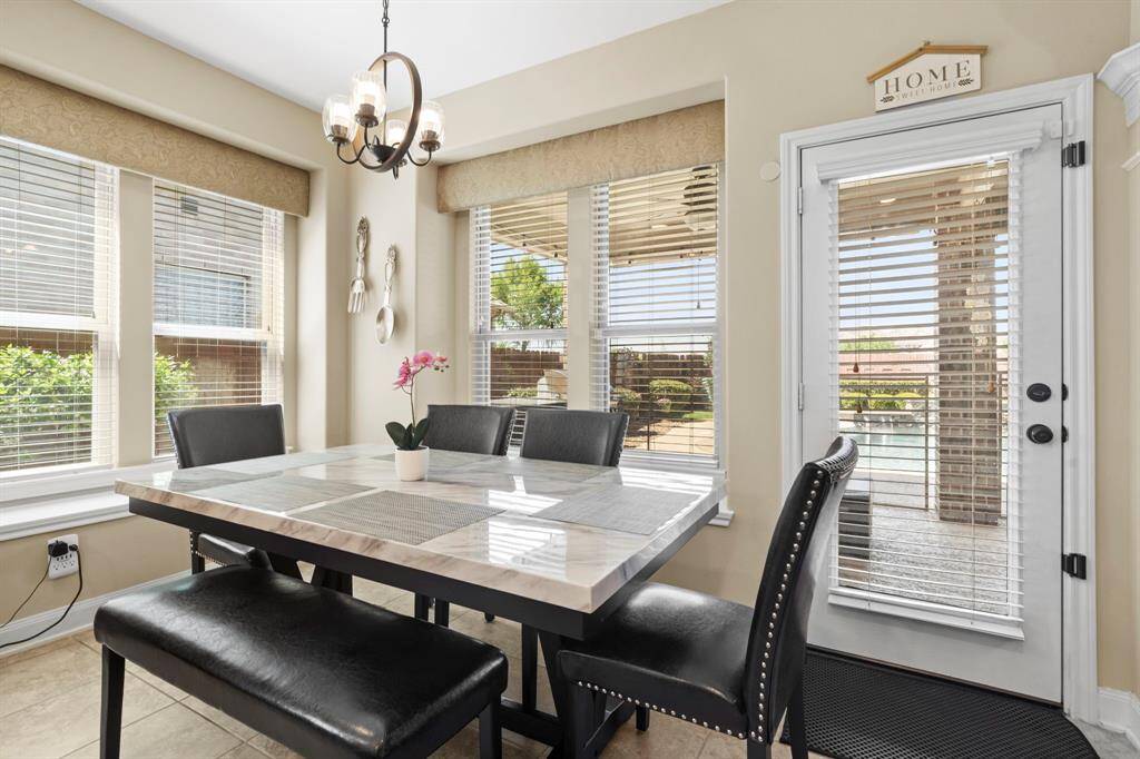The sunny breakfast room, surrounded by windows, offers a relaxing space for casual meals.