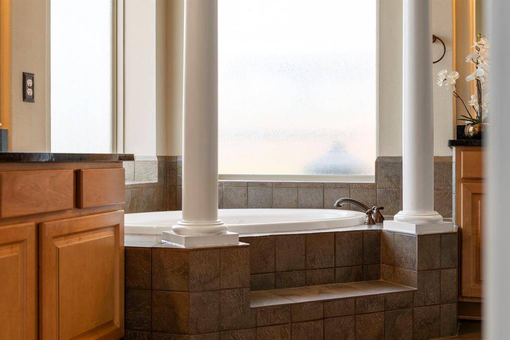 Large obscured glass windows fill the bathing area with soft natural light while maintaining privacy.