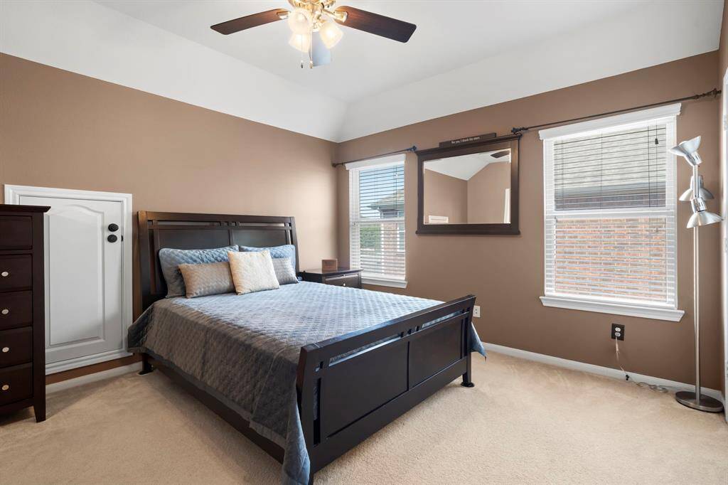 Large windows fill this secondary bedroom with natural light, creating a bright and inviting atmosphere.