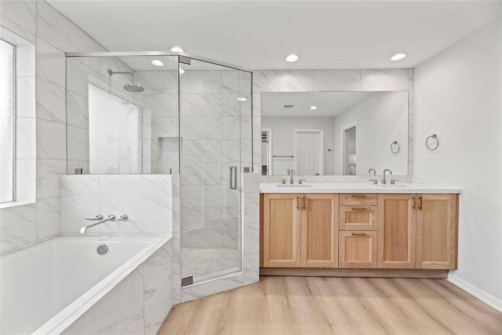 Spa like primary bath with soaking tub, separate shower and double vanity.