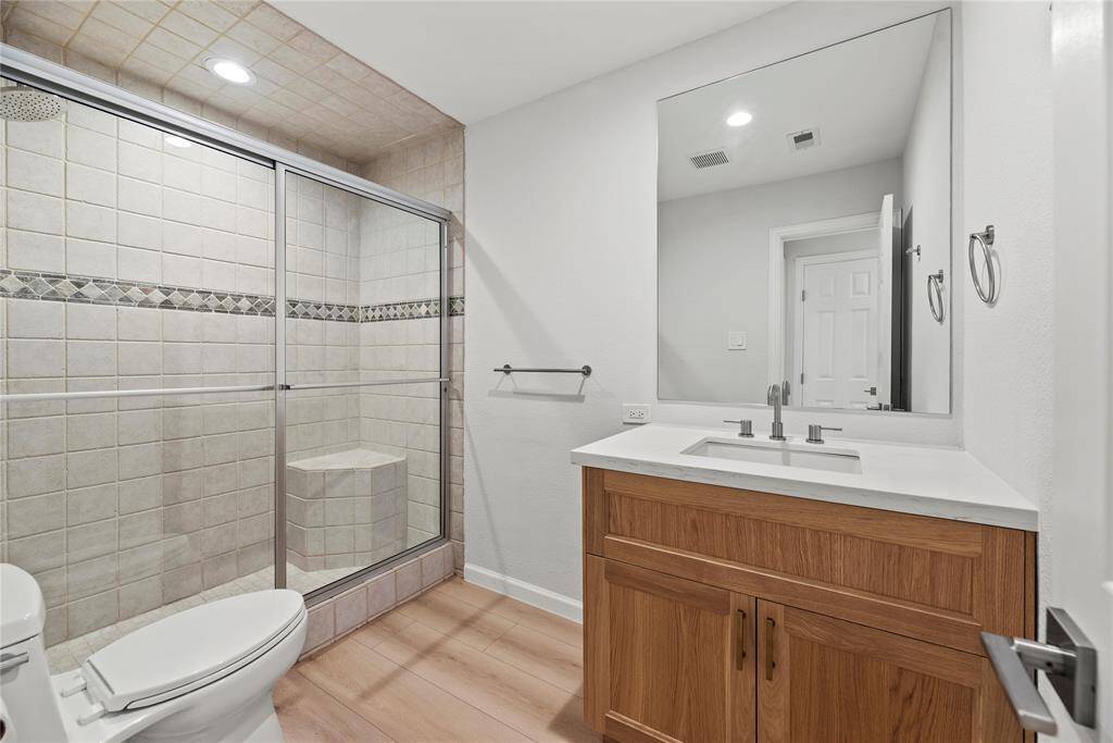Guest bathroom with beautiful new vanity, toilet and glass shower door.