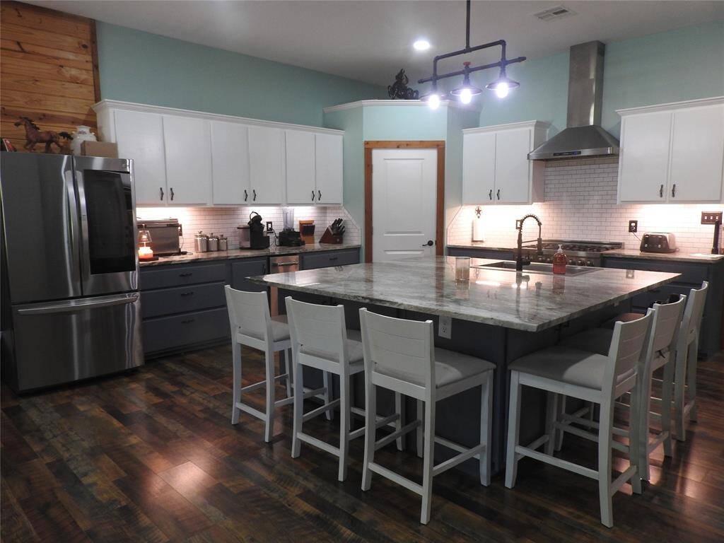 Kitchen with a huge island, outlets and cabinets space. Wood Vinyl Plank Flooring.