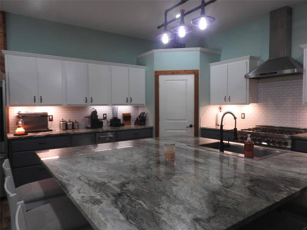 Granite counter on the island as well as the counters. Recessive lighting add to that special elegance. Lots of cabinet spaces and the door straight across is the Food Pantry. Lots of shelving space.