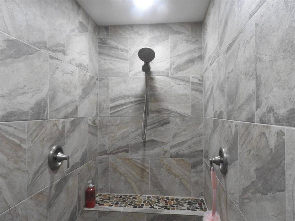 This Custom Shower with two shower heads; one on the wall, the other on the ceiliing above one's head while taking a shower.