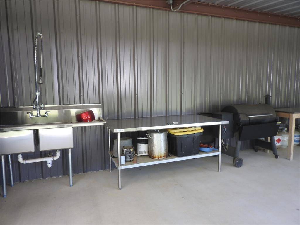 An outdoor grilling area equiped with a commercial sink and storage.