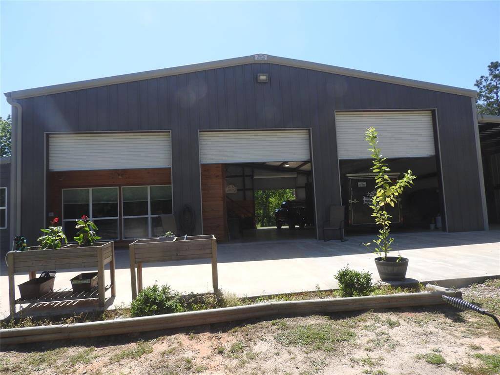 Front of the Barndominium. Cedar displayed in the carport is the Barndominium. The two roll-up doors is the double carport space to park 4-6 vehicles. The first door on the right has an RV Hook-Up to include Water, Electric.