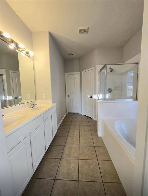 Master Bathroom with his and her vanity, tub and walk in shower