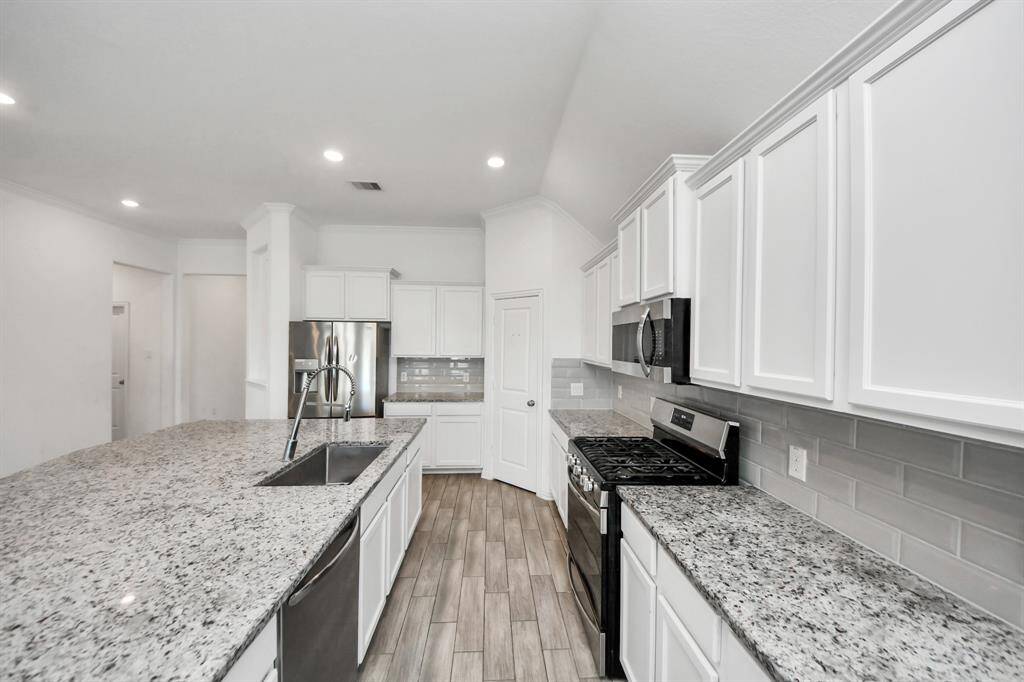 gourmet kitchen is a chef’s dream—complete with modern, stainless steel appliances, a generous breakfast bar, sleek countertops, and abundant cabinetry for all your storage needs.