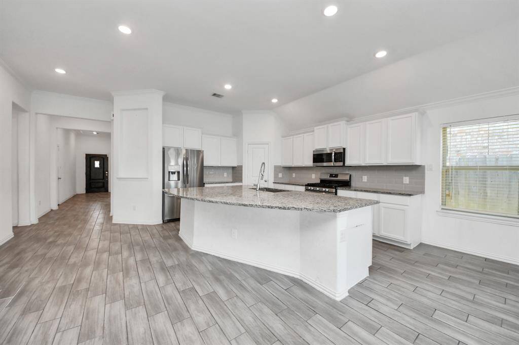 The breakfast bar comfortably seats several guests—perfect for casual meals, morning coffee, or gathering with friends while cooking.