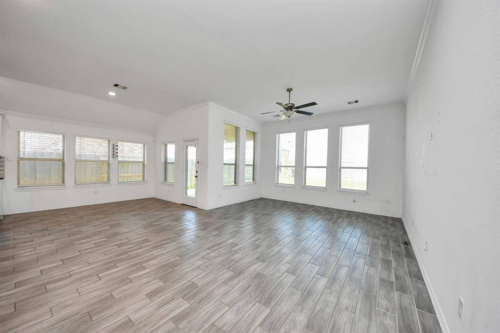 The living room is a bright and welcoming space, designed with an open-concept layout that effortlessly connects to the kitchen and dining areas.