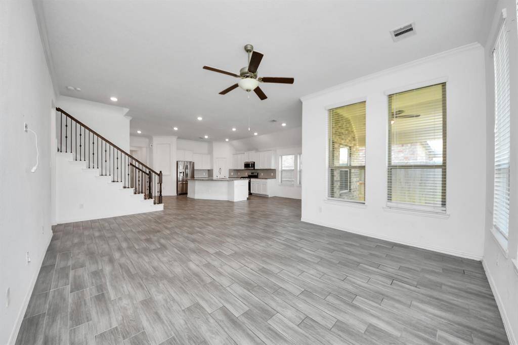 Flooded with natural light from a wall of large windows, the room feels spacious and airy throughout the day.