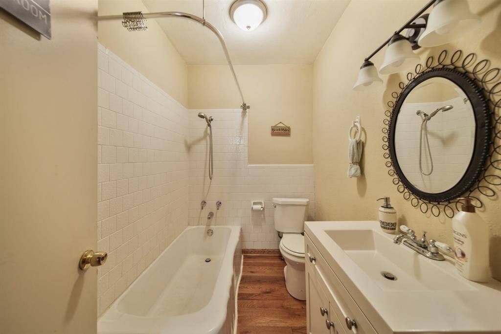 Full bathroom between two bedrooms. Tub with shower in the bath and large rectangle sink