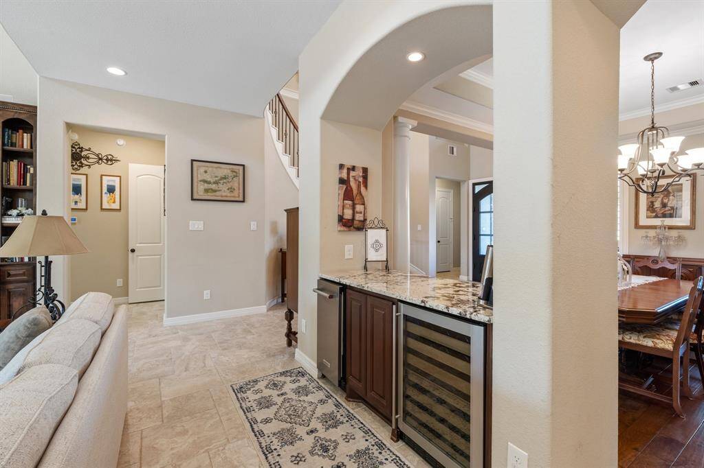 Nestled between the living room and dining room, this built-in storage area features additional granite counter space, an ice maker, and a wine fridge, perfect for entertaining.