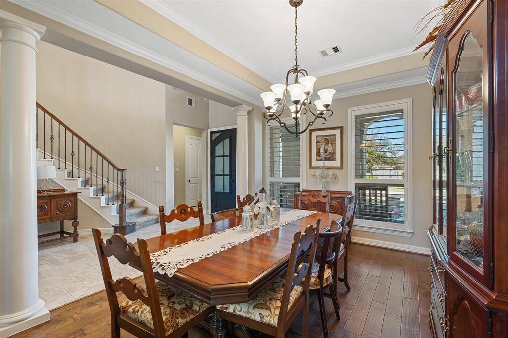 Another view of the dedicated dining room with chandelier, built-in counterspace for serving, and abundant natural light enhancing the welcoming atmosphere.
