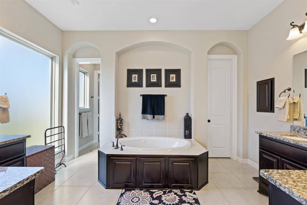 Primary bathroom featuring a separate soaking tub, spacious walk-in shower, and a private water closet. Neutral finishes create a serene, spa-like atmosphere.