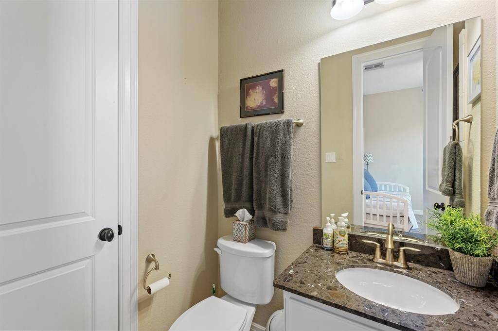 This beautifully appointed ensuite bathroom features elegant finishes that create a refined and relaxing atmosphere. An oversized mirror adds a touch of luxury, enhancing the space with both style and functionality. The thoughtfully designed details make this bathroom a perfect private retreat for guests or family members.