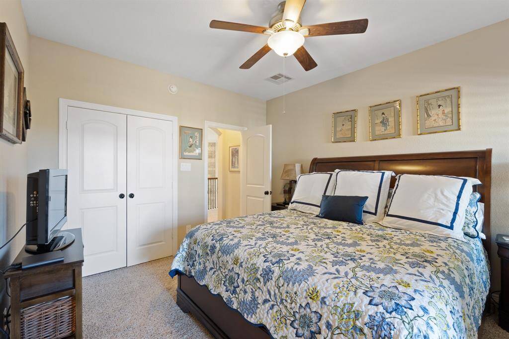 Another view of the cozy secondary bedroom offers a perfect blend of comfort and privacy, featuring direct access to a private balcony for peaceful outdoor moments. The room includes a spacious double-door closet, providing ample storage space.