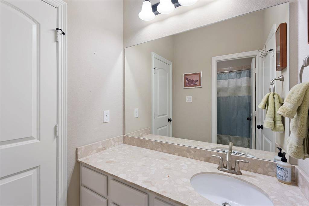 Elegant ensuite bathroom features an oversized mirror that enhances the sense of space and light. The extended countertop offers additional surface area, combining functionality with style.