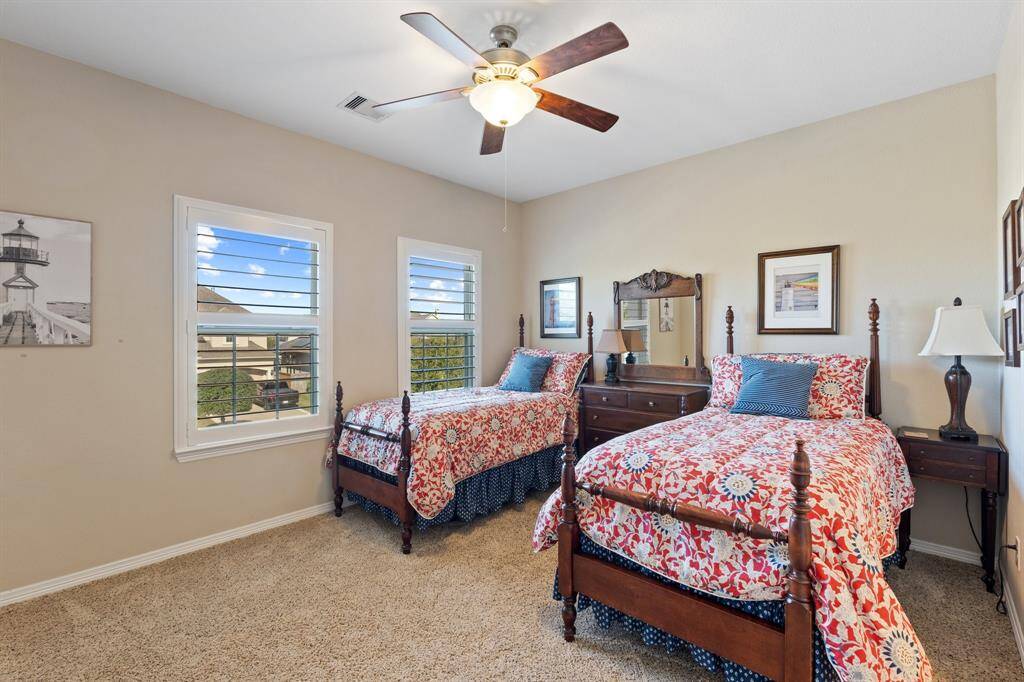 Charming secondary bedroom with oversized windows, plush carpet, and easy access to a Jack and Jill bathroom, perfect for shared living.