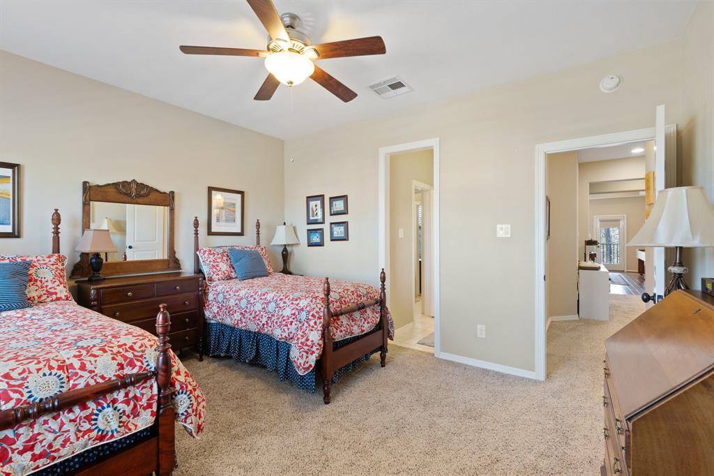 Another view of the secondary bedroom, featuring plush carpet and a Jack and Jill bathroom, designed for shared living with comfort and functionality.
