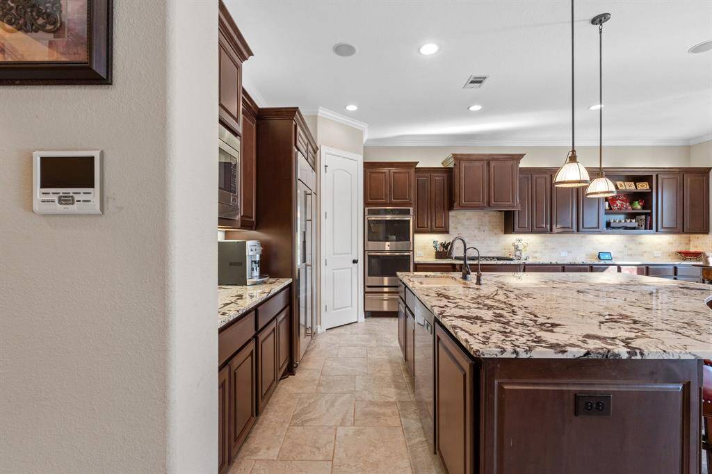 Another view of the kitchen, highlighting the expansive island and granite countertops. This space effortlessly combines beauty and functionality, ideal for cooking and socializing.