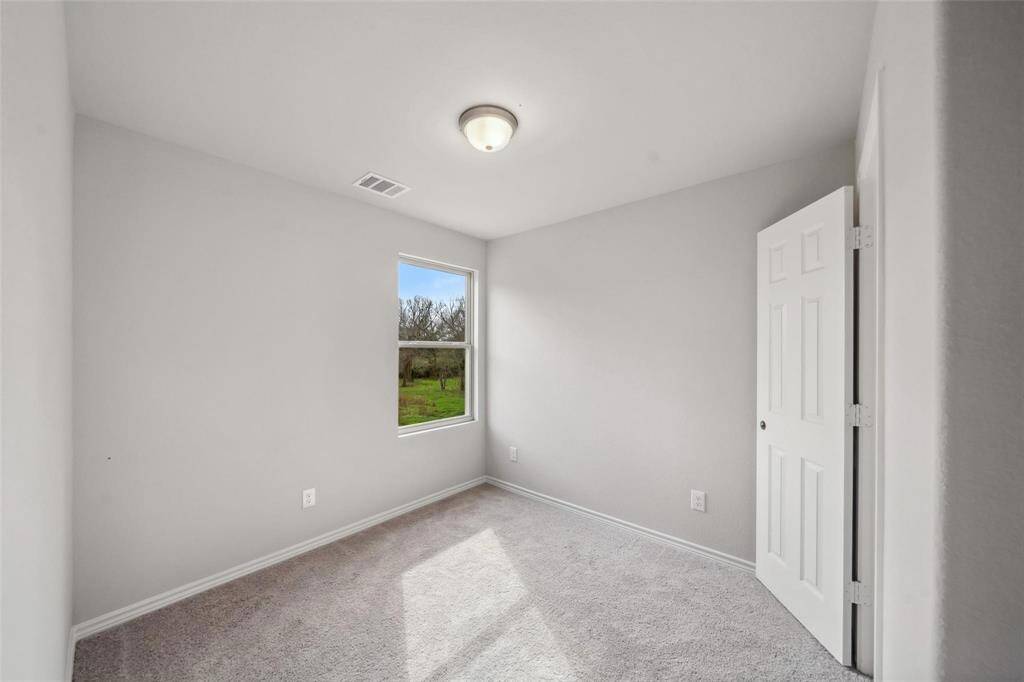 The second bedroom is equally spacious, featuring a large window that lets in plenty of light.