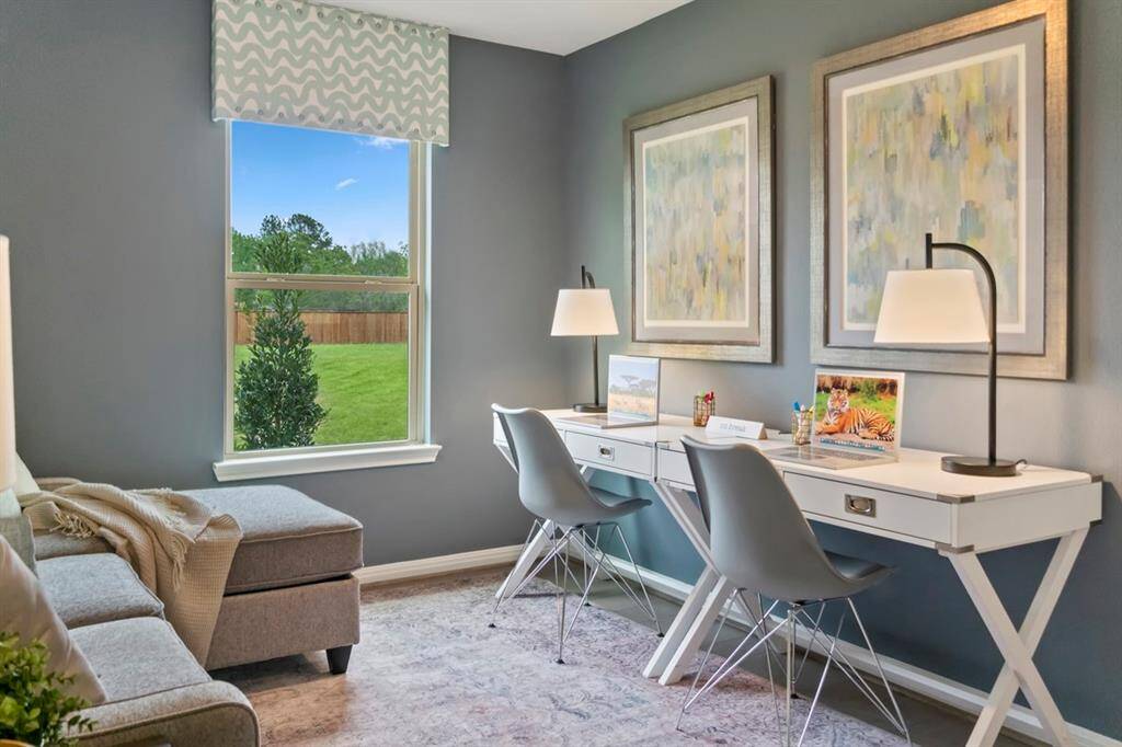 The handsome Den pictured here is used as a home office! It features Canyon Cove Hickory Engineered Wood Flooring, custom paint, high ceilings, and a large window with window covering!