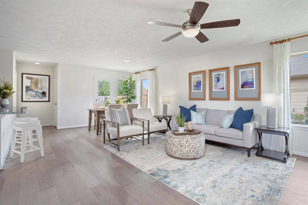 The open concept Great Room, dining and kitchen makes for a impressive way to keep the party going and never miss a beat! Gather the family together in good conversation while preparing a fabulous meal in the breathtaking kitchen! This Great Room features large windows, high ceilings, ceiling fan, recessed lighting, and Canyon Cove Hickory Engineered Wood flooring! NOTE: window coverings, artwork and furniture will be sold with home.